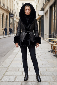 European woman wearing the black belted coat on a sidewalk with her whole face visible