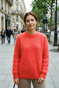 European woman wearing the coral-red crew-neck sweater on a sidewalk