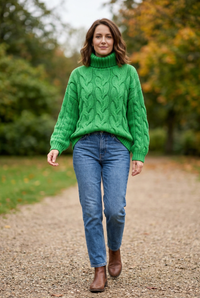 European woman wearing Winnie’s bright green cable-knit jumper outdoors
